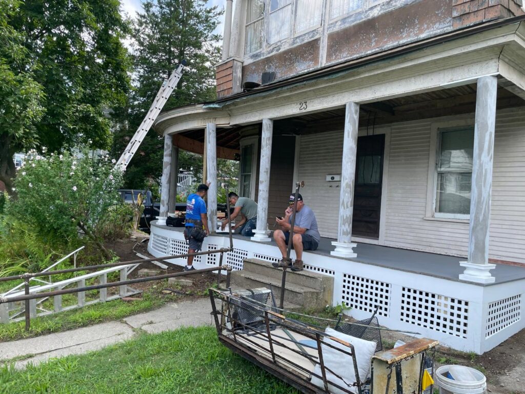 Construction workers performing repair and renovation work on a residential porch by Usa Construction of Danbury LLC in Danbury, CT.
