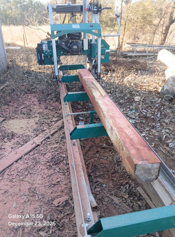 Portable sawmill processing a large log into lumber by D&D Tree Service in Stillwater, OK.