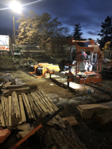 A portable sawmill processing logs into lumber at night for Dancing Bear Woodworks in Spokane, WA.