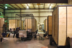Multiple portable units in various stages of assembly on a production line, demonstrating general contractor services by Comforts of Home Services Inc in Aurora, IL