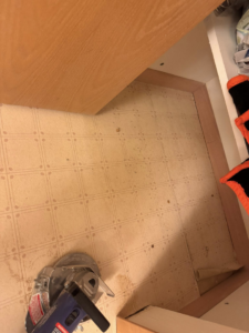 A power tool on an old bathroom floor during removal and preparation by All-In-One Contracting and Home Improvement in Canton, OH