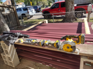 Power tools and a tool belt laid out on stacked wood boards for a project by Do-N-All Handyman Service in Wichita, KS.