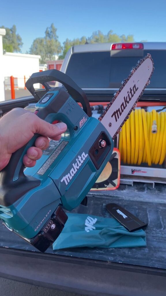 A professional Makita chainsaw being held, representing the quality equipment used by Valley Tree Masters for tree services in Chandler, AZ