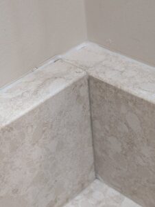 Close-up of expertly installed bathroom tiles in a corner, showcasing quality work by H4 Construction and Remodeling in Blue Springs, MO.