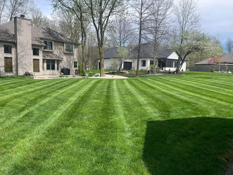 A professionally mowed lawn with striped patterns at a residential property by E&K Property Preservation in Lake, MI.
