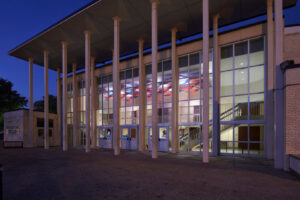 Exterior of a public building with tall columns and glass facade at night, completed by Reeder General Contractors, Inc. in Fort Worth, TX