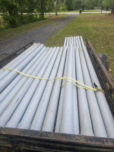 A trailer loaded with grey PVC pipes, ready for a project by Lowcountry Current LLC in Moncks Corner, SC.