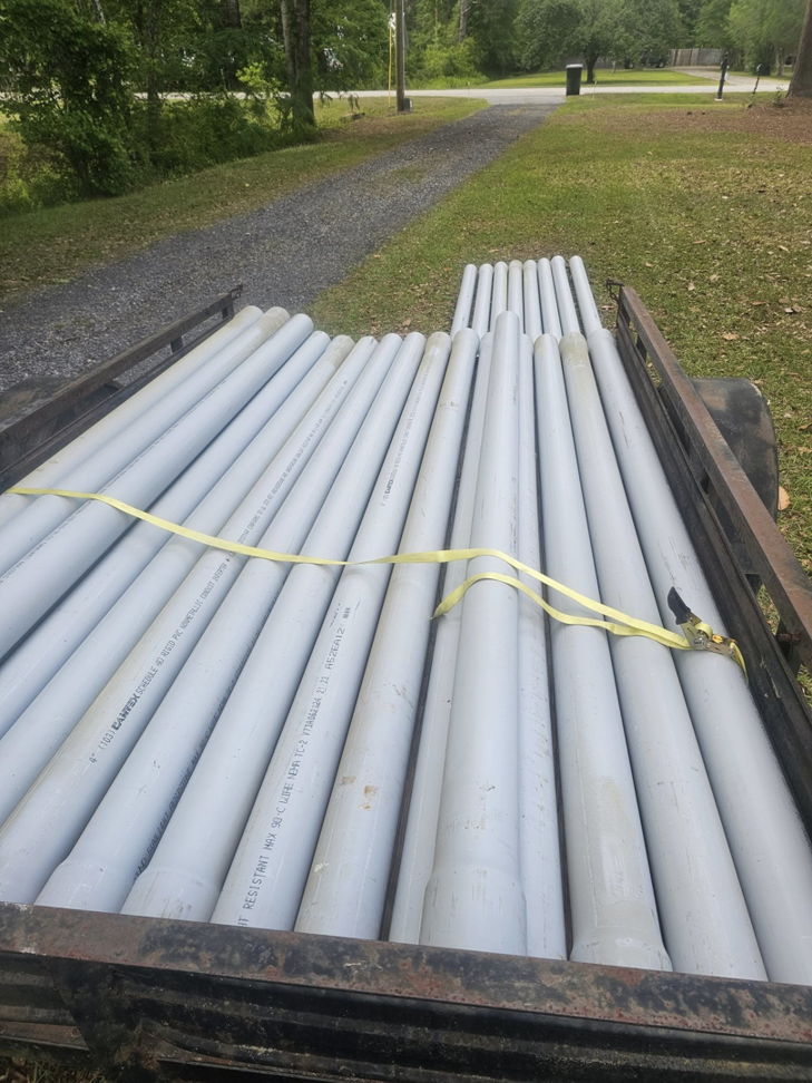 A trailer loaded with grey PVC pipes, ready for a project by Lowcountry Current LLC in Moncks Corner, SC.