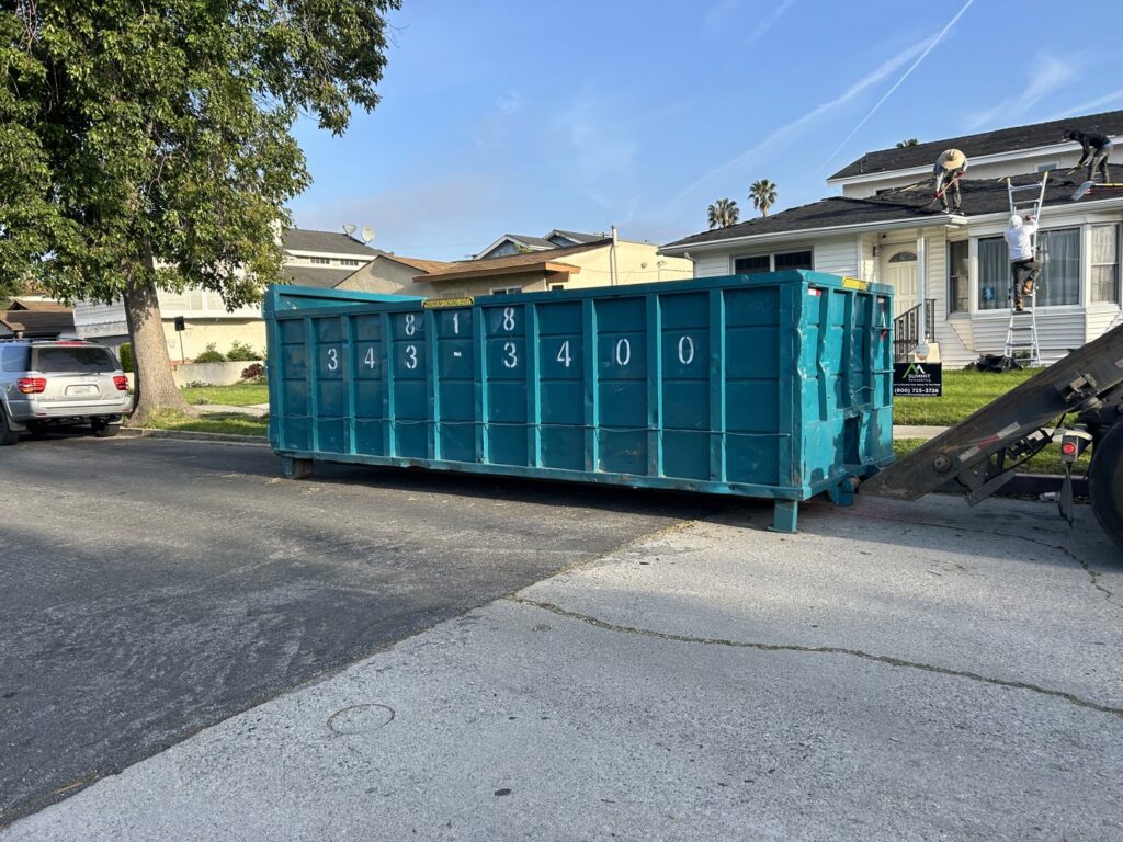 A Quality Bin Inc. dumpster being used for a roofing junk removal job on a street in Los Angeles, CA.