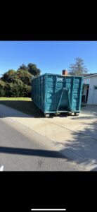 A Quality Bin Inc. dumpster placed on a residential driveway for junk removal in Los Angeles, CA.