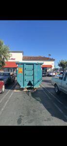 A Quality Bin Inc. dumpster placed in a commercial parking lot for junk removal in Los Angeles, CA.