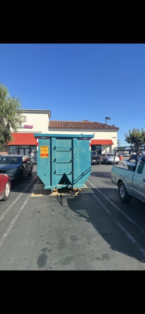 A Quality Bin Inc. dumpster placed in a commercial parking lot for junk removal in Los Angeles, CA.