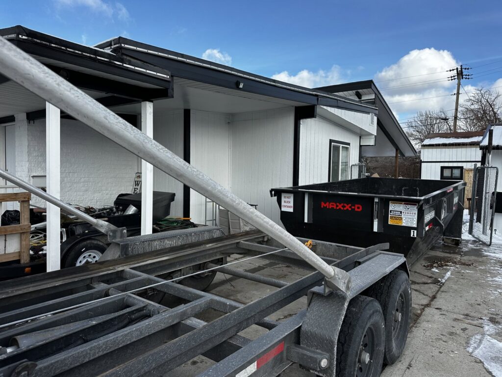 A RAAAM Dumpster Rentals roll-off dumpster being delivered to a property in Salt Lake City, UT.
