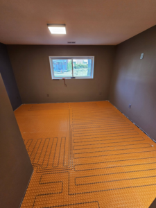 Radiant floor heating underlayment being installed in a room by AIS Home Service's in St. Louis, MO.