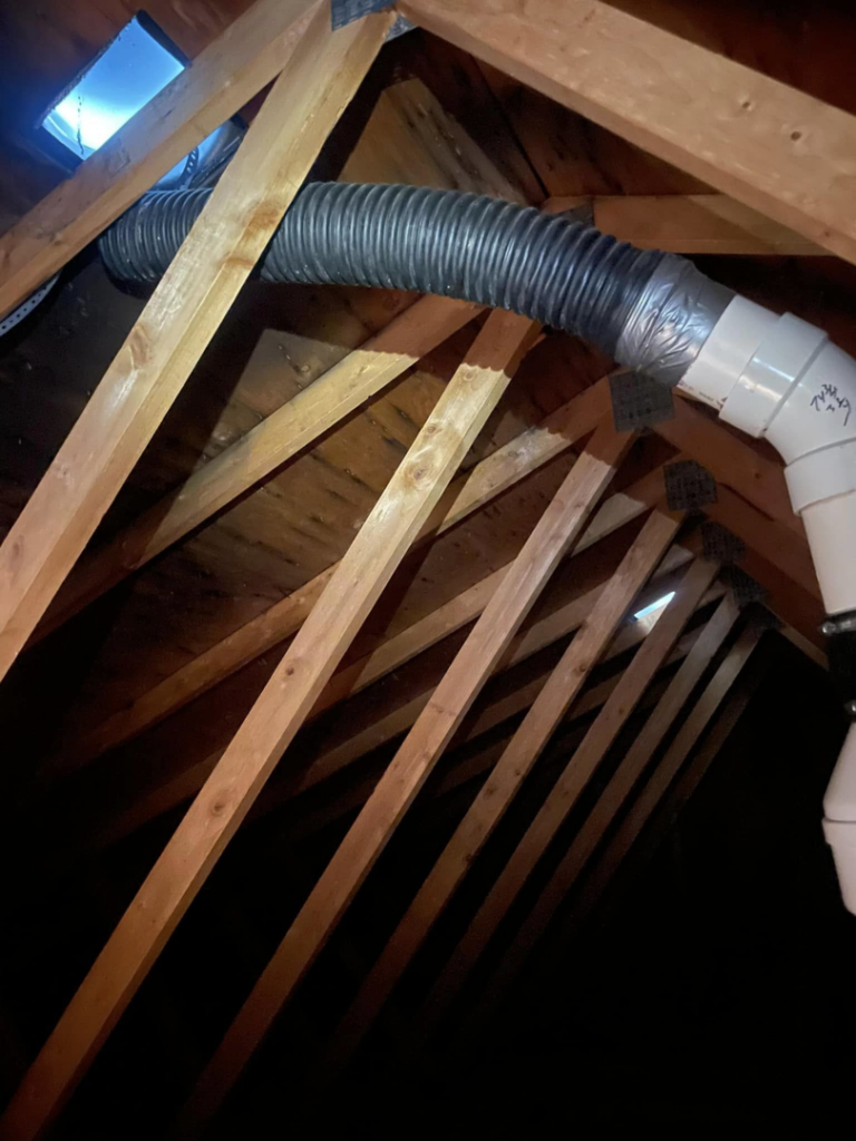 A flexible duct and PVC pipe installed in an attic for a radon mitigation system by Rocky Mountain Radon Solutions in Fort Collins, CO.