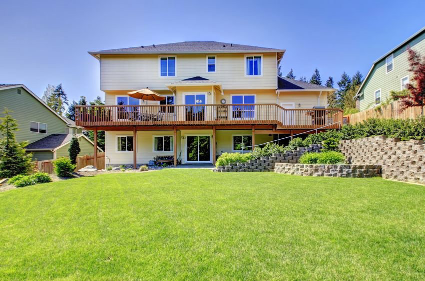 A large raised backyard deck overlooking a green lawn by St. Charles Deck in St. Charles, MO