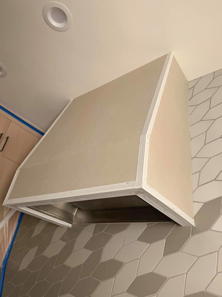 A custom range hood frame with corner beads installed, ready for plastering by Plasters of Italy in Plano, TX