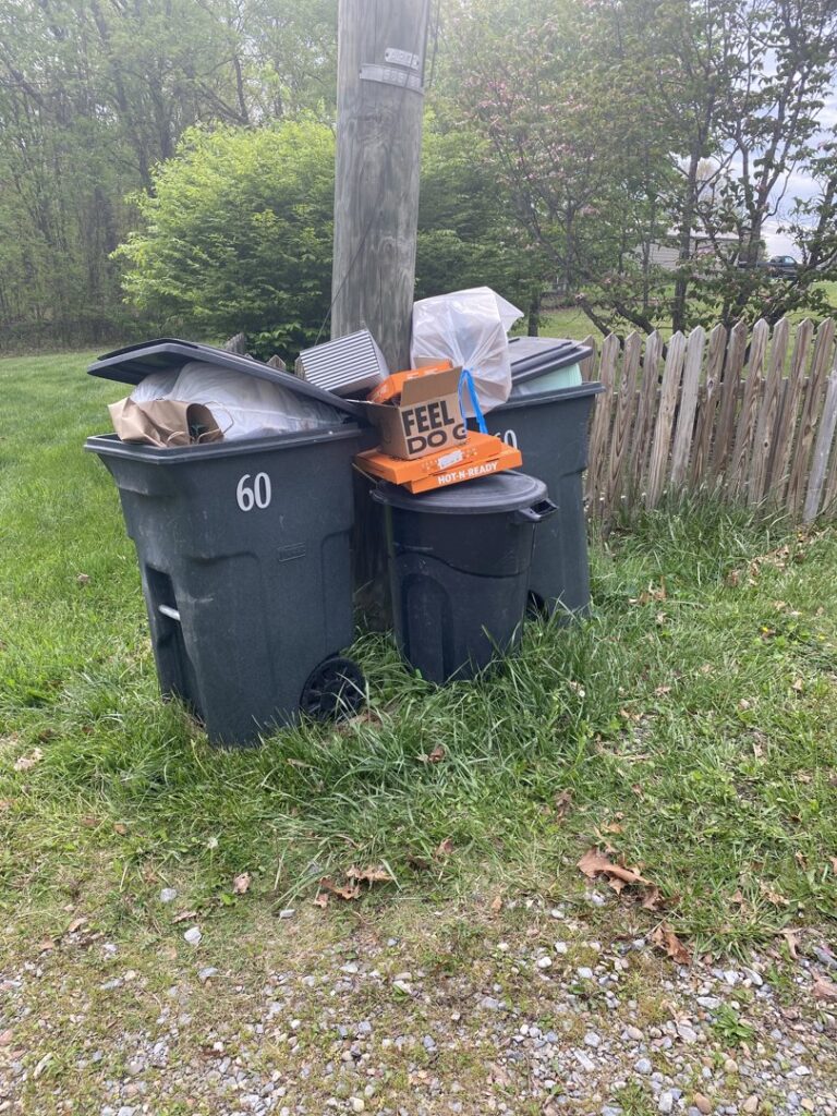 The rear of a garbage truck with a "SLOW DOWN TO GET AROUND" warning sign from Whitecap Waste in Beckley, WV.
