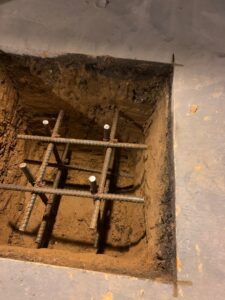 A rebar cage placed in an excavated pit for a footing or foundation, work by MCG General Contractor in Philadelphia, PA.