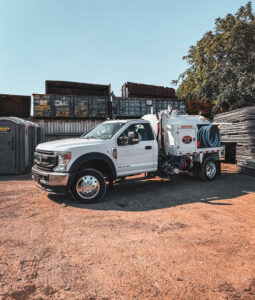 A recycling yard with large roll-off dumpsters and a service truck at Valley Services - Valley Recycling in San Jose, CA