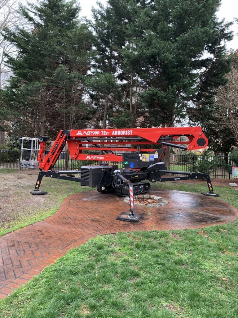 A red JLG Platform 72ft Arborist lift parked on a lawn, used by Scott Lanes Tree Service in Chesapeake, VA.