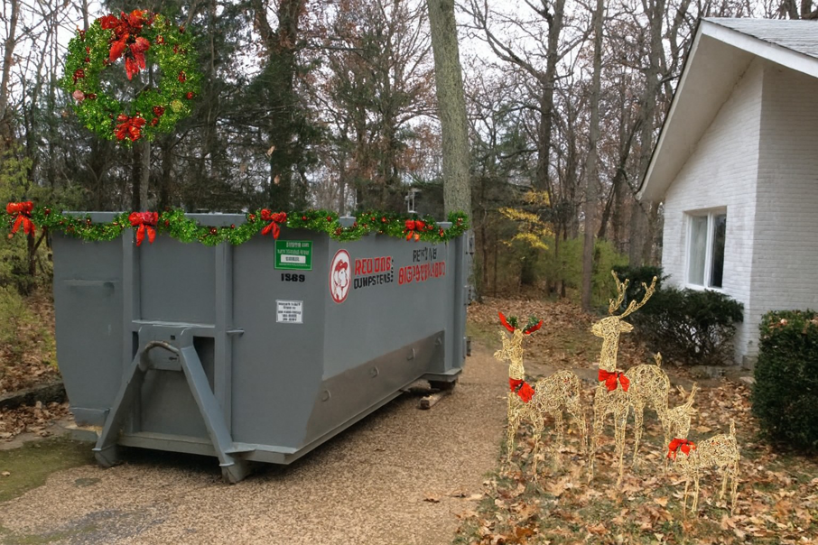 A Red Dog Dumpsters rental dumpster decorated with Christmas garland and a wreath outside a home in Nashville, TN