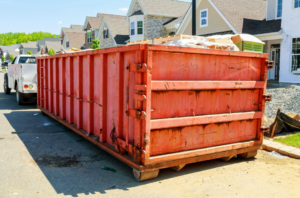 A large red dumpster filled with construction debris on a street, ready for general junk removal by Galluzzo Brothers Carting in Newark, NJ.