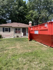 A red dumpster from 515 Dumpsters placed in front of a residential house in West Des Moines, IA.