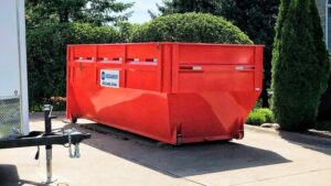A red dumpster from 515 Dumpsters placed on a residential driveway in West Des Moines, IA.