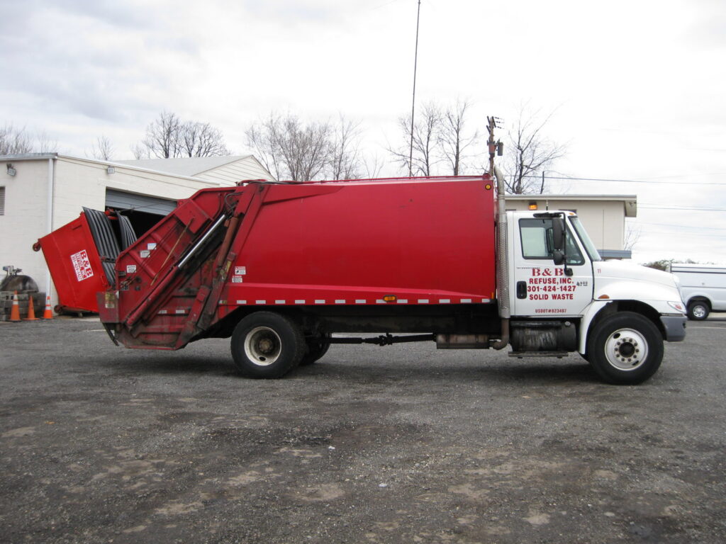 A red and white garbage truck, branded B & B Refuse Inc, ready for junk removal services in Rockville, MD.