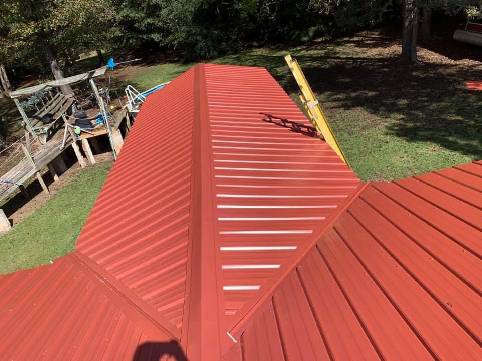 An aerial view of a vibrant red metal roof installation by Hill Renovations LLC, providing durable roofing in Athens, GA