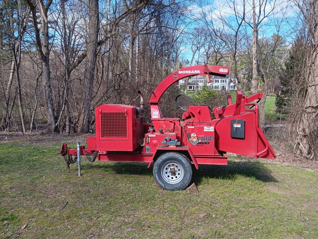 A red Morbark wood chipper in a grassy area, ready for use by S&D Tree Service LLC in Schenectady, NY.