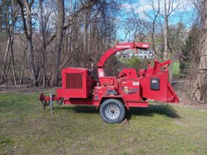 A red Morbark wood chipper in a grassy area, ready for use by S&D Tree Service LLC in Schenectady, NY.