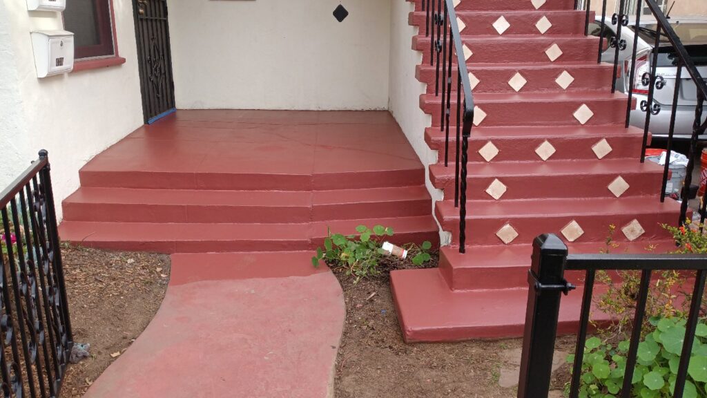 A newly painted red concrete porch and steps, a renovation project by Juancho's Handyman in Salida, CO.