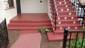A newly painted red concrete porch and steps, a renovation project by Juancho's Handyman in Salida, CO.
