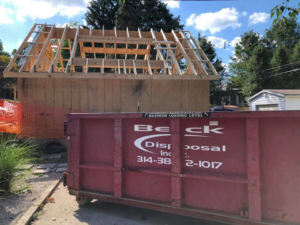A red roll-off dumpster from Beck Disposal Inc. on a construction site in St. Louis, MO
