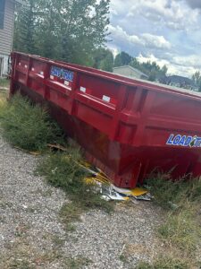 A red roll-off dumpster from Jedi Junk Removal Garbage Services Pocatello, ID, placed on a residential driveway.