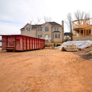 A red roll-off dumpster at a residential construction site for junk removal services by RBS Sanitation Inc. in Tea, SD.