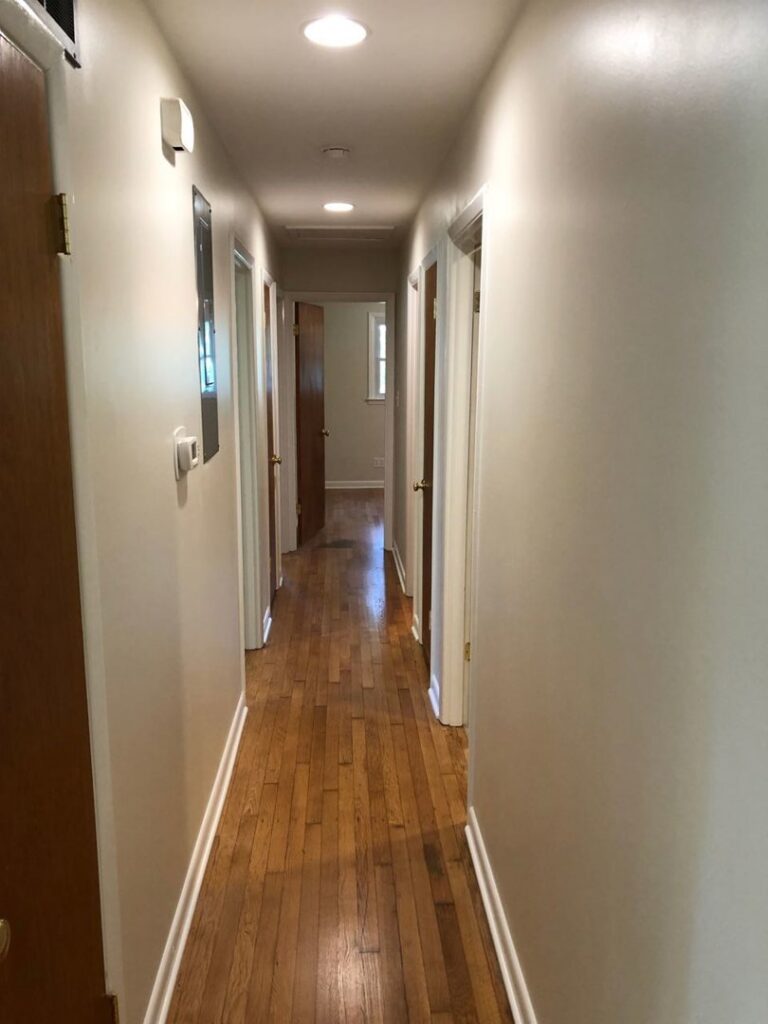 A clean residential hallway featuring a beautifully refinished hardwood floor by Franco's Hardwood Flooring in Durham, NC.