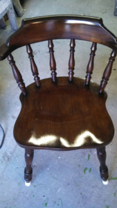 A beautifully refinished dark wooden chair with a glossy finish, completed by Symphonic Painting in Oshkosh, WI.