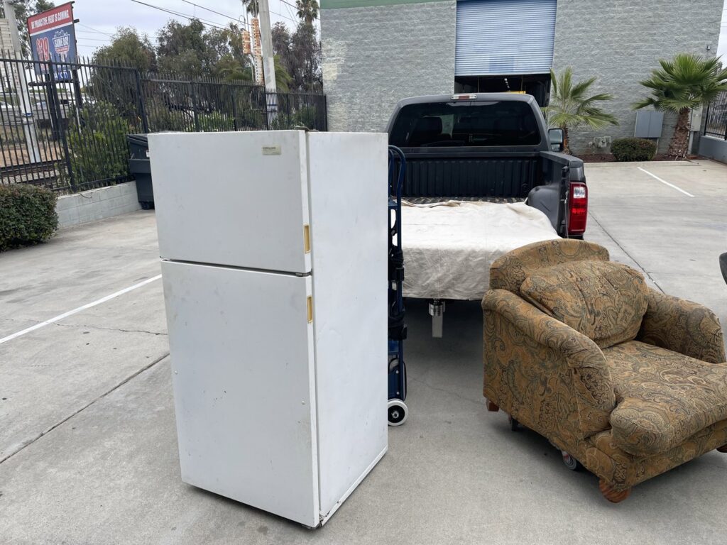 A refrigerator and an armchair placed outside, ready for appliance and furniture removal by Eastlake Hauling and Junk Removal, LLC in Chula Vista, CA.