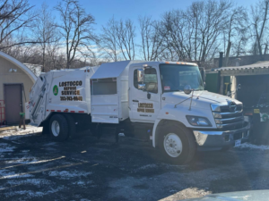 A white refuse truck with LoStocco Refuse Service branding parked in Danbury, CT, ready for junk removal.