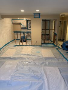 Room set up for remediation with plastic containment, exposed studs, and drying equipment by Coyote Restoration in North Richland Hills, TX.