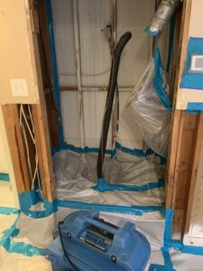 Room set up for remediation with plastic containment and a HEPA air scrubber by Coyote Restoration in North Richland Hills, TX.