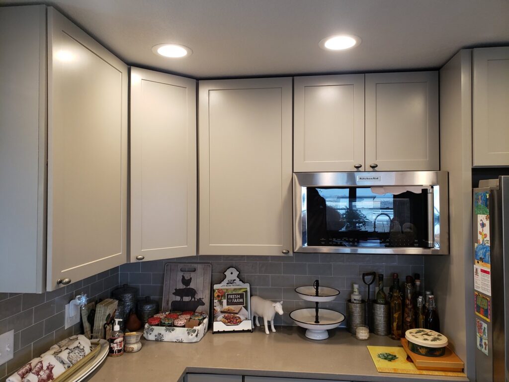 A newly remodeled kitchen featuring new cabinets, microwave, and recessed lighting by Rosewalls Handyman & Remodeling in Des Moines, IA.