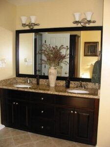 A beautifully renovated bathroom featuring a double vanity, large mirror, and modern light fixtures by WHE Construction in Virginia Beach, VA