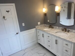 A beautifully renovated bathroom with a double vanity by Wood Trades LLC in Westport, MA.