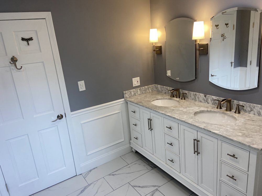 A beautifully renovated bathroom with a double vanity by Wood Trades LLC in Westport, MA.