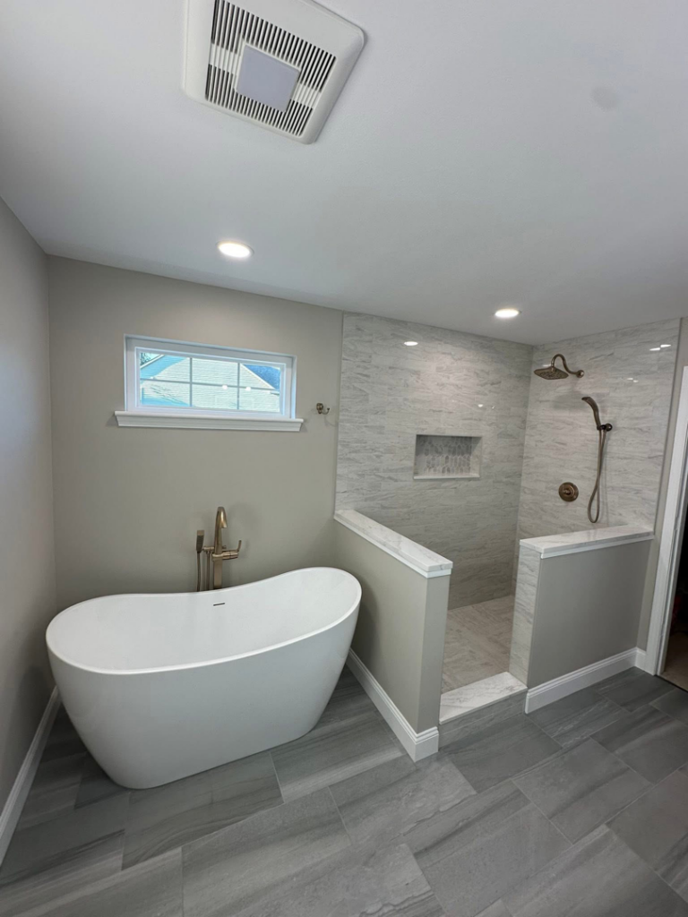 A beautifully renovated bathroom featuring a freestanding tub and walk-in shower by Quality Work Home Services in Syracuse, NY.
