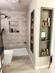 A renovated bathroom shower area with tiled walls and built-in shelving by Blue Ribbon Renovations in Elizabethtown, KY.